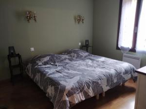 a bedroom with a bed with a comforter on it at Gîte l' Odyssée in Espalion