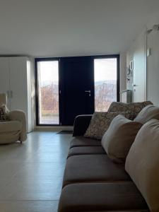 un soggiorno con divano e 2 finestre di La casa de lu Barone a San Demetrio neʼ Vestini