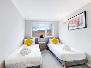 1 dormitorio con 2 camas y ventana en 5 MINS to Slough Trading Estate - Free Onsite Parking, WiFi - Sleeps 4 en Slough