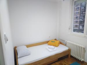 Cette petite chambre comprend un banc avec un sac jaune. dans l'établissement Anastasija Apartman, à Novi Sad