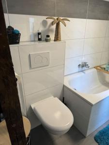 a white bathroom with a toilet and a sink at 4711 Suite in Siegburg