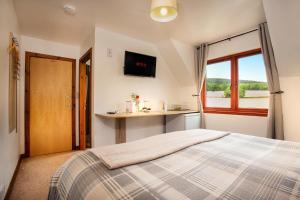 a bedroom with a large bed and a window at Beechwood Lodge Guesthouse in Alness