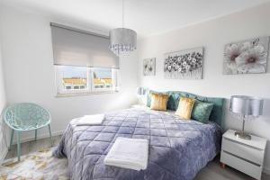 a bedroom with a blue bed and a blue chair at Vista MarVilla Eira Nova in Porto Covo