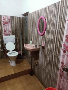 y baño con lavabo rosa y aseo. en Gyanbhumi Homestay Ayodhya, en Faizābād