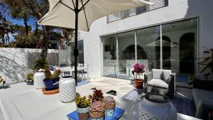een patio met een bos potten en een paraplu bij Casa Blu Marbella in Marbella