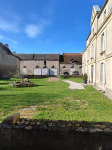 CreullyにあるGîte Le Prieur é - COEUR DE BOURG - maison 48 M2の草の庭が目の前にある古い建物