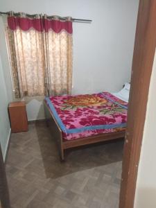 a small bed in a room with a window at Royal Queen Residency in Ooty
