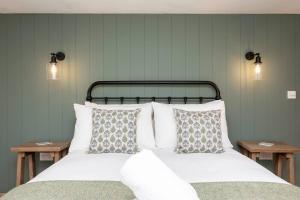 Una cama con sábanas blancas y almohadas en un dormitorio en Pass the Keys Character two bed with free parking, en Chailey
