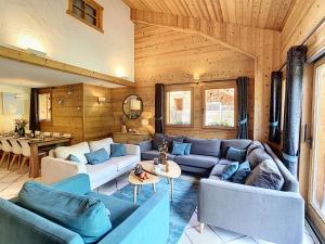 a living room with blue couches and a table at Chez Arsene - appartement - 10 pers - proche piste in Les Gets