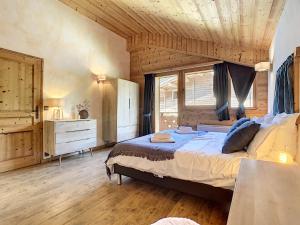 1 dormitorio con 1 cama grande y techo de madera en Chez Arsene - appartement - 10 pers - proche piste, en Les Gets