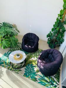 twee stoelen en een tafel op een vloer met planten bij DaLù suite terrace in Bari