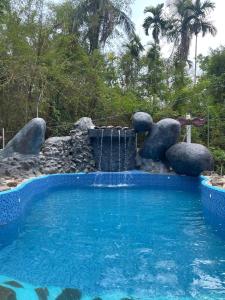a swimming pool with a water slide in a yard at Mazhavilkadu ForestResort & Restaurant in Kozhikode