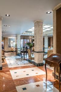 Relais & Châteaux Hotel Orfila في مدريد: لوبي مع طاولة وكراسي وبيانو