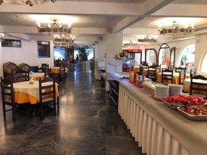 a restaurant with a counter with food on it at Karteros Hotel in Karteros