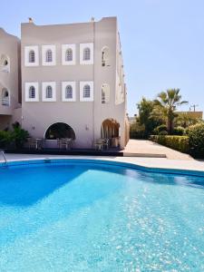 a large swimming pool in front of a building at Karteros Hotel in Karteros
