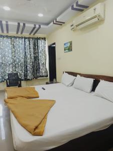 una camera da letto con un grande letto bianco e una finestra di ON GREEN RESIDENCY a Secunderābād