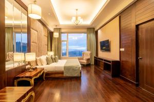 una camera d'albergo con un letto e una grande finestra di The Orchid Hotel Shimla a Shimla