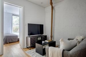 a living room with a couch and a flat screen tv at Classic LES 1br w wd nr SoHo NYC-646 in New York