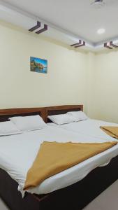 um quarto com uma cama grande e lençóis brancos em ON GREEN RESIDENCY em Secunderābād
