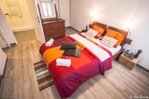 um quarto com uma cama grande com cobertores e almofadas coloridos em Chic apart with parking near Paris em Colombes