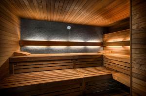 an empty sauna with wooden walls and wooden benches at FAVORITE Parkhotel I Spa - Business - Fine Dining in Mainz +35 photos