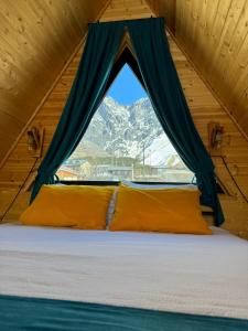 un letto in una stanza con una finestra di Qusha Cottage a Kazbegi