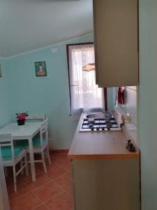 cocina con fogones horno superior junto a una mesa en New! La Ginestra,casa vacanze in montagna-Seulo Sardegna, en Seùlo