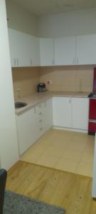 an empty kitchen with white cabinets and a sink at Stan na dan M&M in Lug