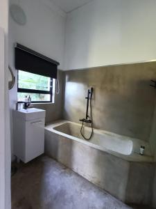een badkamer met een bad en een wastafel bij Lieu De Grace in Johannesburg