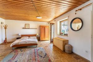 a bedroom with a bed and a wooden ceiling at Fuchsbau Ferienwohnung am Chiemsee in Seeon-Seebruck