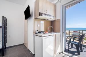 cocina con balcón con vistas al océano en Iguana studio 13, en Preveza