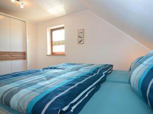 Schlafzimmer mit einem Bett mit blauen und weißen Streifen in der Unterkunft Modern Apartment in Eslarn with Lake Near in Eslarn