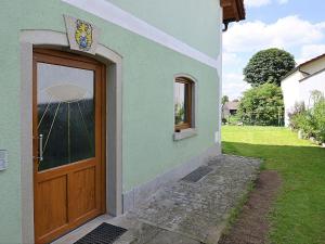 a house with a wooden door and a yard at Modern Apartment in Eslarn with Lake Near in Eslarn