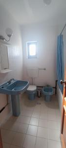 La salle de bains est pourvue d'un lavabo bleu et de toilettes. dans l'établissement Alojamentos Vitinho 3 for Walkers, à Vila Nova de Milfontes