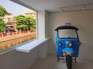 a small blue motorcycle parked next to a window at Line Bangkok Hostel in Bangkok