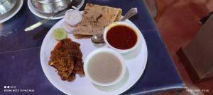 a plate of food with meat and bread and dipping sauce at The Jungle Resort Amba in Chandoli