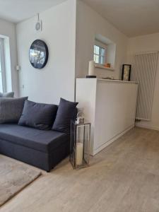 a living room with a couch and a clock on the wall at -NEUE- Ferienwohnung - Monteurwohnung in Lippe in Lage +12 photos