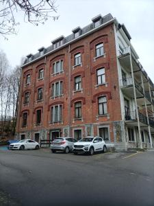 two cars parked in front of a brick building at Forest 104 in Vielsalm