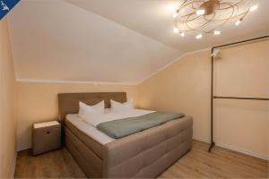 ein kleines Schlafzimmer mit einem Bett mit einer Decke in der Unterkunft Ferienhaus Becker Ferienwohnung Brücke in Heringsdorf