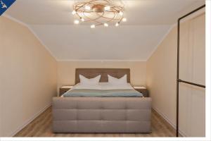 ein Schlafzimmer mit einem großen Bett mit Kronleuchter in der Unterkunft Ferienhaus Becker Ferienwohnung Brücke in Heringsdorf