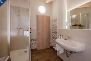 ein weißes Badezimmer mit Waschbecken und Dusche in der Unterkunft Ferienhaus Becker Ferienwohnung Brücke in Heringsdorf + 17 Fotos