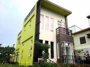 a yellow and white building with a balcony at Time Travel B&B in Taitung City
