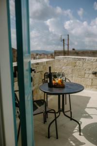 einen Tisch mit einer Flasche Wein und Obst darauf in der Unterkunft Smaragda's Guest Rooms in Limassol