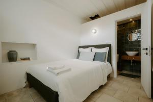 a bedroom with a large white bed and a sink at Smaragda's Guest Rooms in Limassol