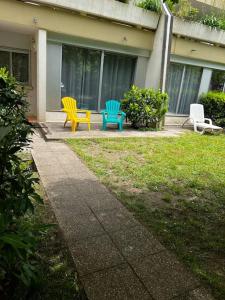 tres sillas coloridas sentadas fuera de una casa en F2 bord d’allier avec jardin clos en Moulins