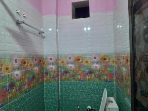 a bathroom with a shower with a mural of sunflowers at Ram priya plaice 5 mint waking Ram mandir in Ayodhya
