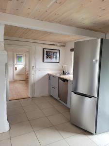 uma cozinha com um frigorífico de aço inoxidável em Ragnhilds Gård, Hostel em Nyord