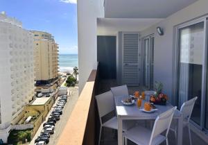 Un balcón con mesa y sillas y el mar. en ELITE RESIDENCE 10F, en Portimão