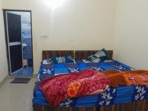 a bedroom with a bed with a blue comforter at Ram priya plaice 5 mint waking Ram mandir in Ayodhya