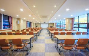 an empty lecture hall with tables and chairs at Doya Hotel Geoje in Geoje  +37 photos